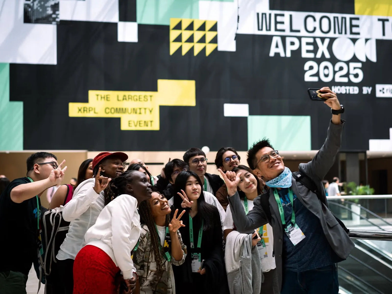 XRP community members taking a selfie at the Apex 2025 entrance